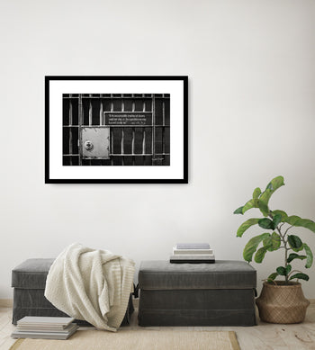 A framed inspirational art piece featuring a quote by Martin Luther King Jr., displayed on a wall above a bench with a plant and books to the side.