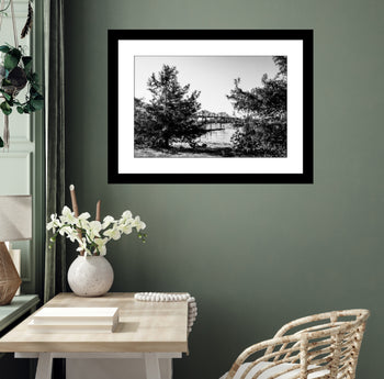 Black and white photograph of the Tennessee River Bridge in Decatur, Alabama, showing steel architecture and reflections in the river.