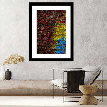 Photograph of a red vine on a yellow and blue abandoned building in Decatur, Alabama, showing vibrant colors and urban decay.