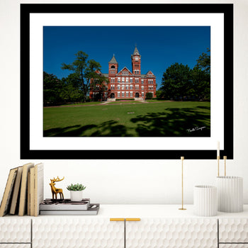 A framed landscape canvas print featuring Samford Hall, Auburn University, with a clear blue sky and greenery in the background.