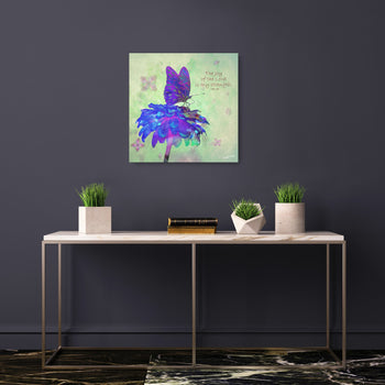 A canvas print featuring an artistic representation of a purple butterfly with blue and green accents, displayed above a table with plants and books.