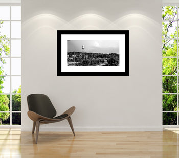Black and white panoramic photograph of the Lincoln Mill Water Tower in Downtown Huntsville, Alabama, with a commercial train passing mounted on a wall.
