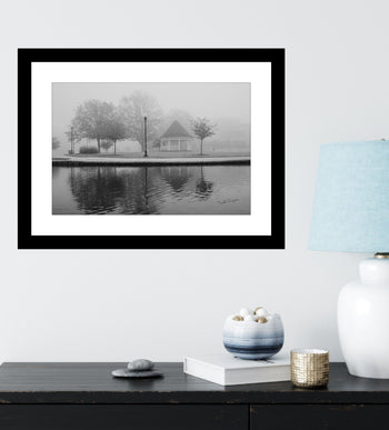 Black and white print of a foggy morning at Big Spring Park Gazebo over the lake mounted on a wall.