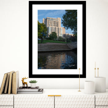 A framed art print depicting a view of City Hall Building in Downtown Huntsville, Alabama, with a reflection on water.