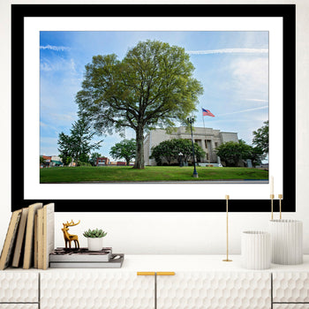 A framed artwork featuring the Lawrence County Court House in Moulton, Alabama, with a tree and a flag in the background.